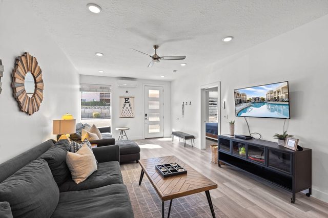 Living room seating facing the TV and front entry door