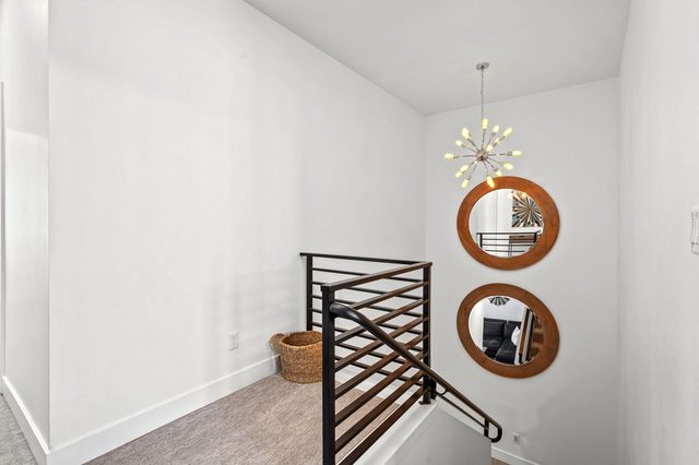 Upstairs landing with modern stair railing and round mirrors