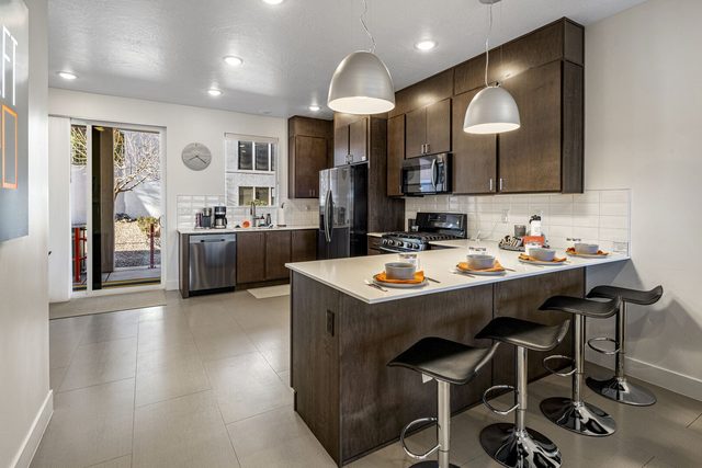Kitchen peninsula with four bar stools and pendant lights