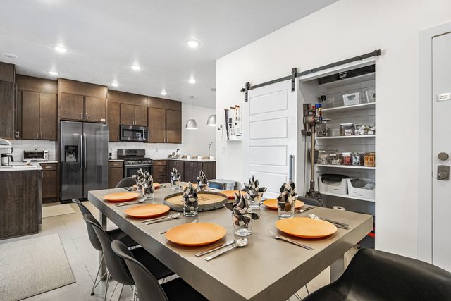Dining table with kitchen and open pantry behind