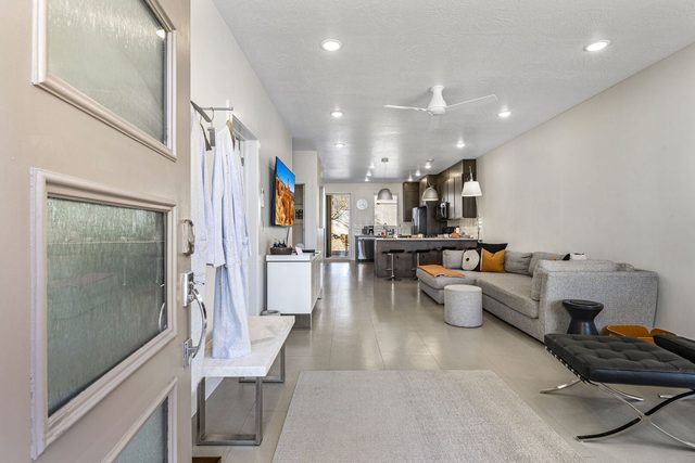 Entry with robes on hooks opening to the living area