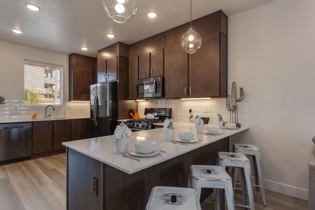 Kitchen island with four stools and dark wood cabinets