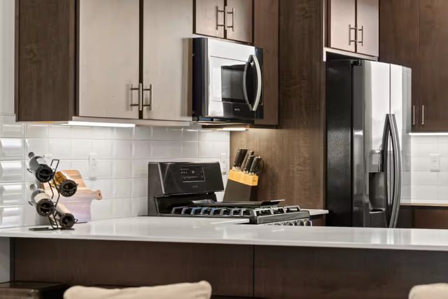 Gas range, microwave and stainless refrigerator in the kitchen