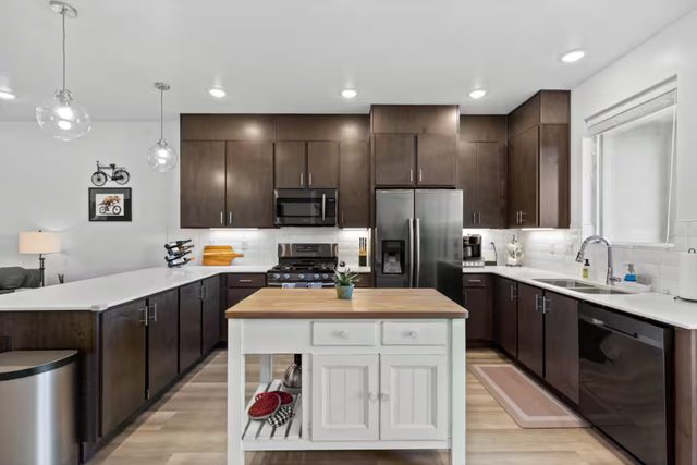 Full kitchen with butcher block island and stainless appliances