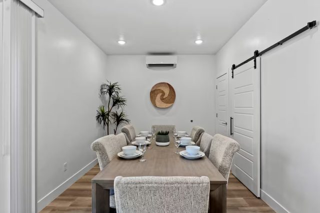 Dining table for six beside a sliding barn door
