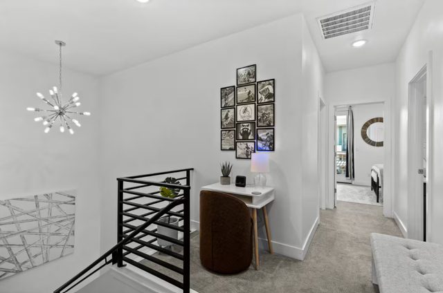 Upstairs landing with small desk and framed photo wall