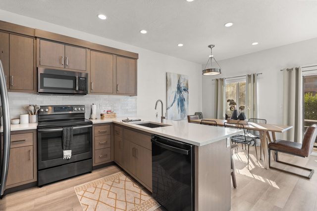 Kitchen with electric range, dishwasher and dining area beyond