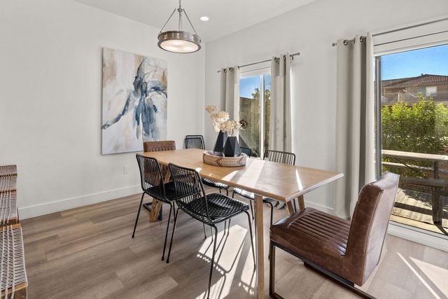 Dining table with leather and metal chairs by patio doors