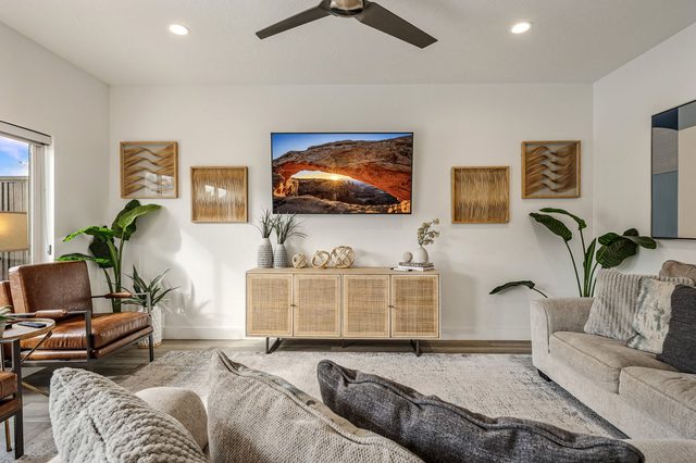 Living room with sectional, leather chairs and mounted TV