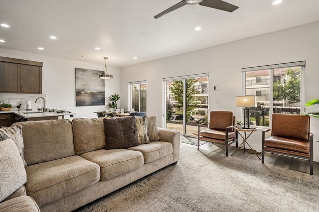 Sectional and leather armchairs near sliding patio doors