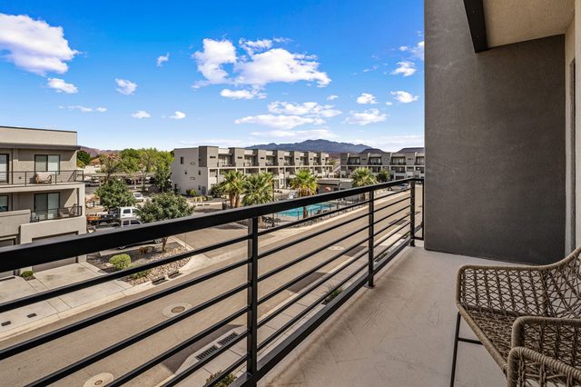 Balcony view of palm trees, community pool and mountains