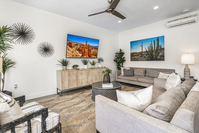 Living room seating with desert artwork and TV