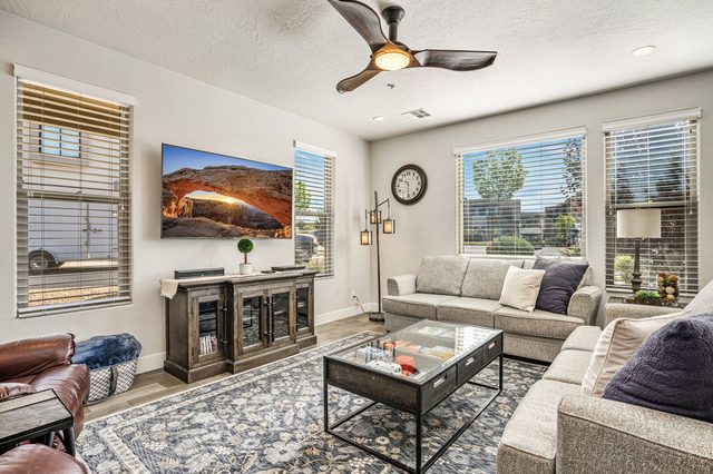 Living area with sectional seating, glass coffee table and TV console