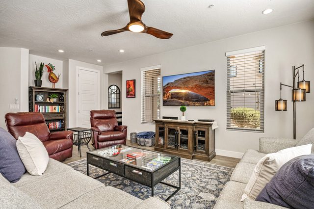 Main living room with recliners, bookshelf and mounted TV