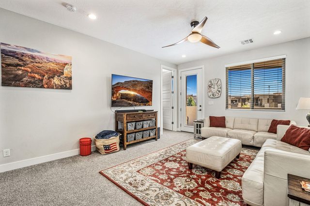 Upstairs family room with white sectional and wall TV