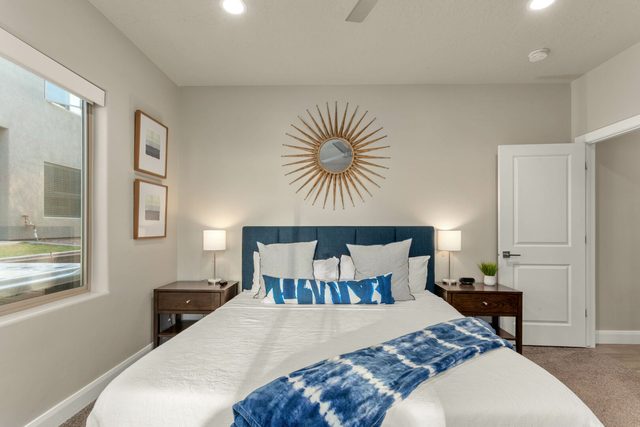 King bedroom with blue headboard and sunburst mirror at Zion Village 2065