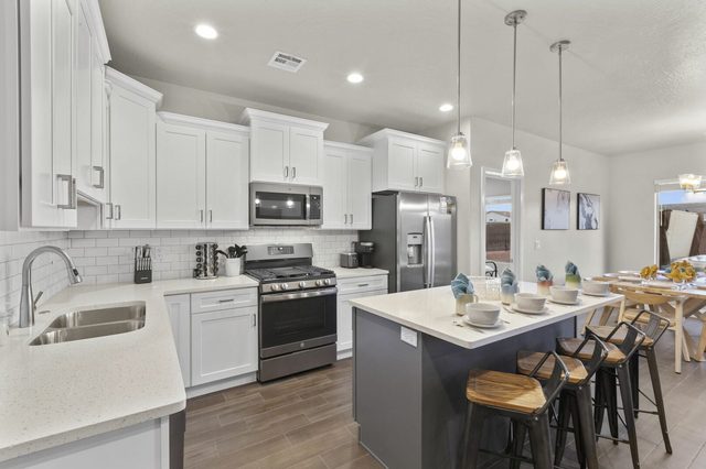 Kitchen with corner sink, island seating and dining area beyond