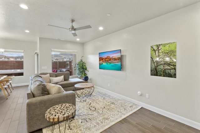 Living room with sectional sofa, TV and backyard windows