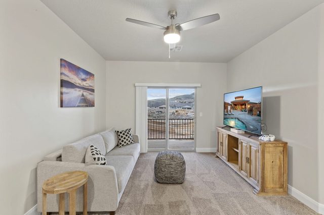 Upstairs loft with sofa, TV and door to the balcony