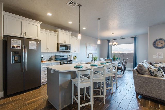 Kitchen island with four bar stools and stainless refrigerator