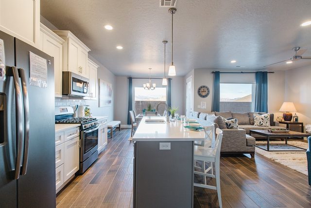 Kitchen with gas range and island open to living room