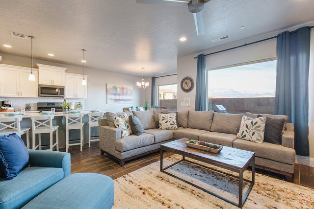 Open living room with sectional and kitchen at Zion Village 2102