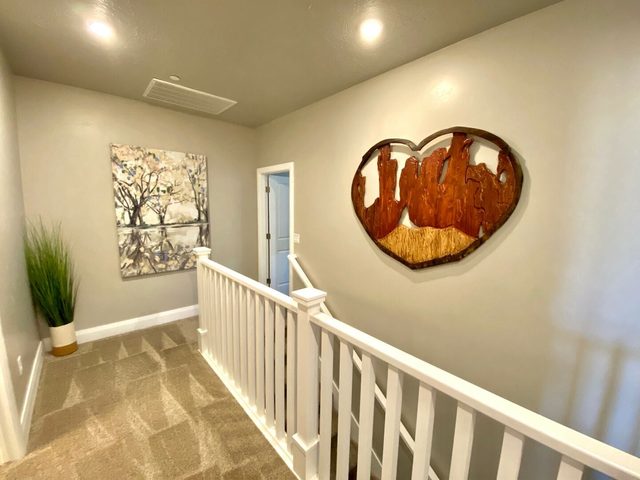 Upstairs hallway with railing and heart-shaped wall art