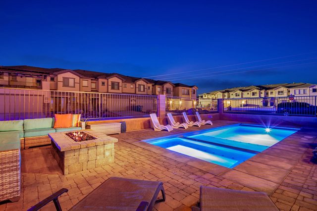 Private pool and fire pit lit up at dusk