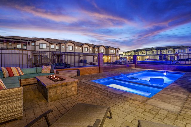 Private pool, fire table and lounge seating under sunset sky