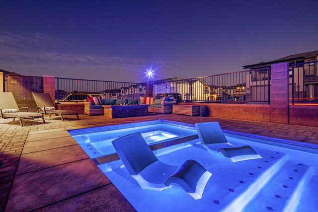 In-pool lounge chairs on the tanning ledge at night
