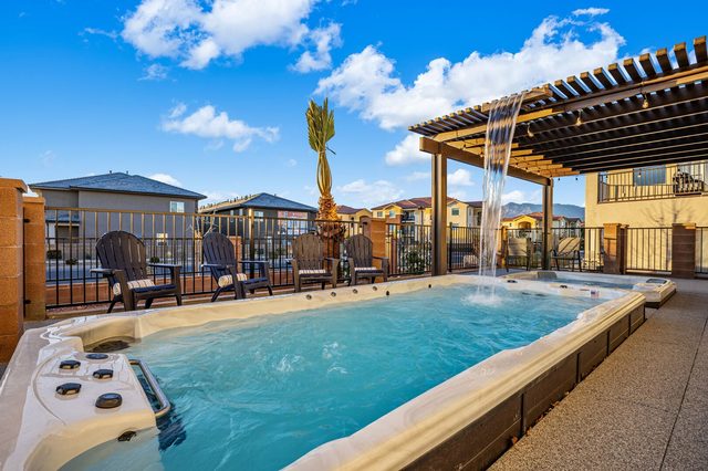 Private heated swim spa with waterfall beside the pergola