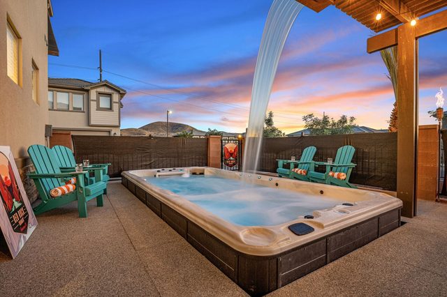 Swim spa waterfall and Adirondack chairs at sunset
