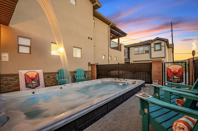 Swim spa with waterfall and teal Adirondack chairs
