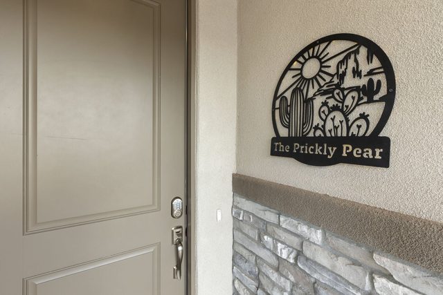 Front door with Prickly Pear metal sign and stone accent