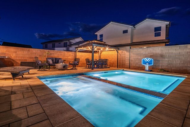 Private pool and hot tub lit at dusk at Zion Village 268