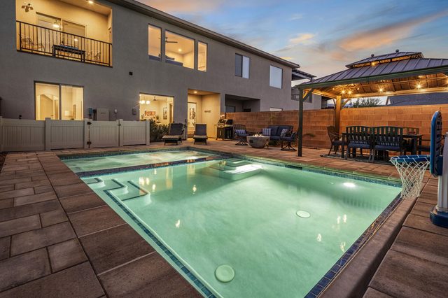 Private pool, gazebo and back of house at dusk