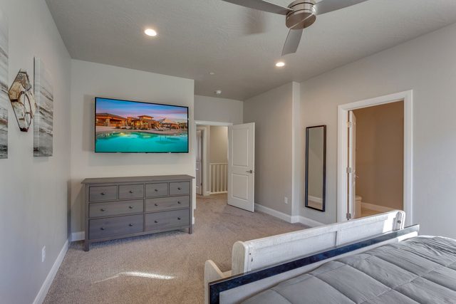 King master suite with dresser and wall-mounted TV