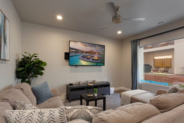 Living room seating with TV and window to the patio