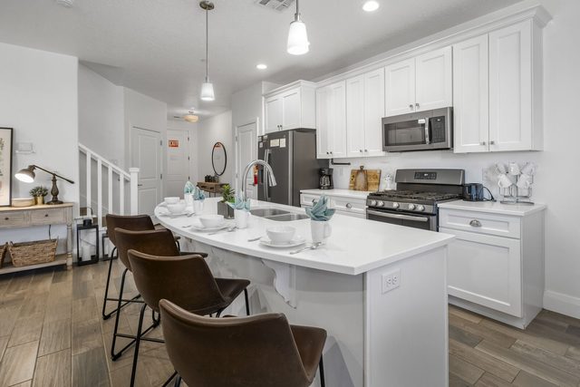 White kitchen with island seating and gas range