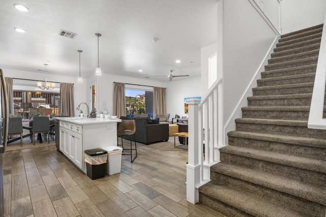 Entry hall and staircase looking into kitchen and living area