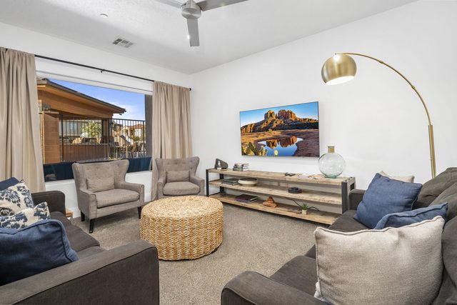 Living room with wall TV, armchairs and patio window