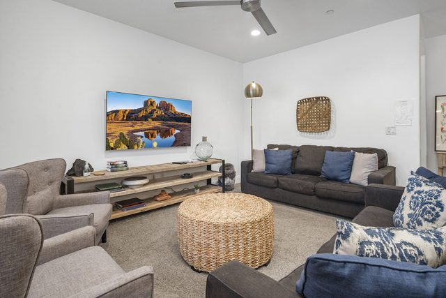 Living room seating around woven ottoman and TV console