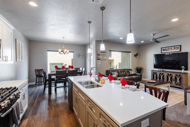 Kitchen island with sink looking into dining and living areas